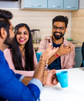 arabian men and women sitting in kitchen and discussing a news.