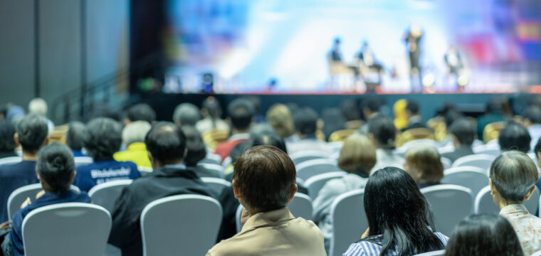 Rear view of Audience listening Speakers on the stage in the conference hall or seminar meeting, business and education about investment concept